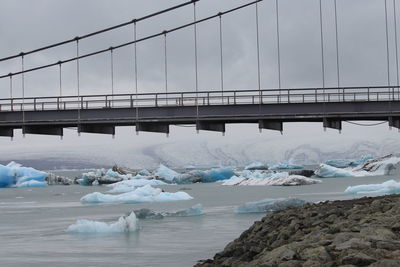 Bridge over sea against sky during winter