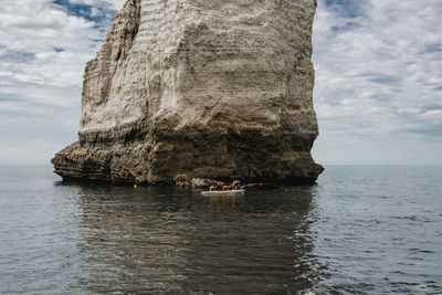 Rock formation in sea against sky