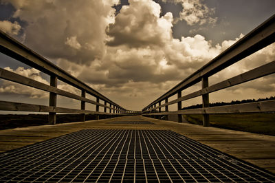 Bridge over river against cloudy sky