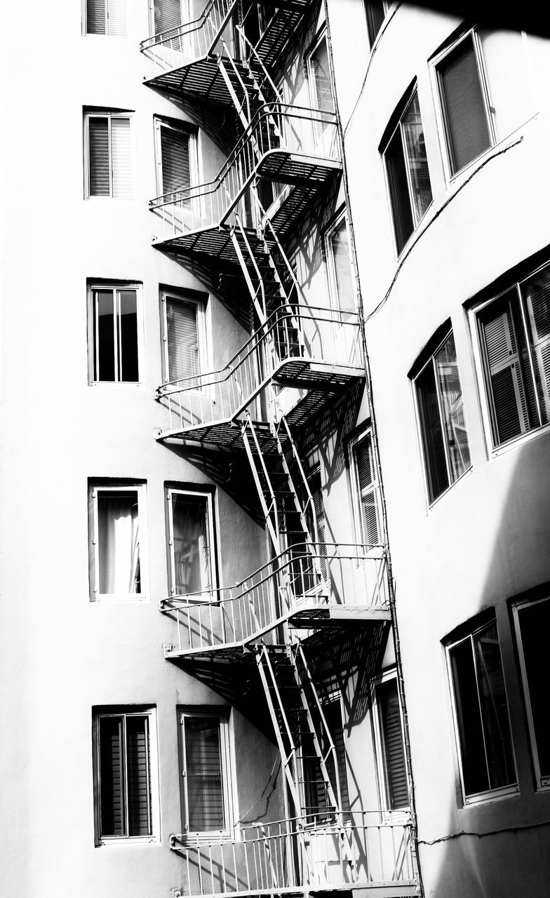 building exterior, built structure, architecture, building, window, residential district, fire escape, staircase, steps and staircases, low angle view, railing, no people, emergency exit, day, safety, accidents and disasters, city, urgency, outdoors, apartment