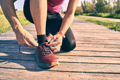 Low section of man tying shoelace