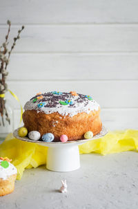 Place setting for easter on the bright background with easter cake with colorful topping, 