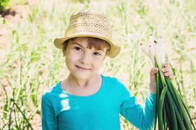 Portrait of young woman wearing hat against plants