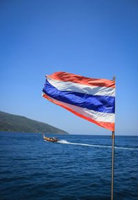 Boat in sea against clear blue sky