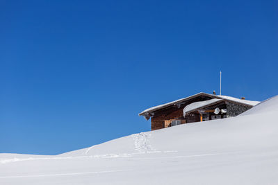 Low angle view of house on snowcapped mountain against sky