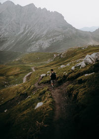 Rear view of hiker going down a mountain