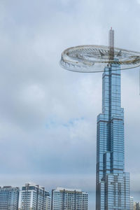 Low angle view of modern building against cloudy sky