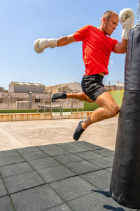 Man kickboxing outdoors