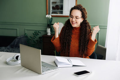 Portrait of young woman using laptop at home