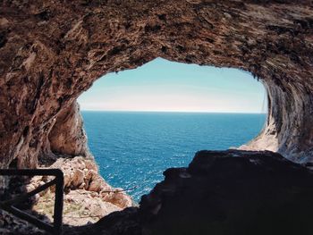 Scenic view of sea seen through cave