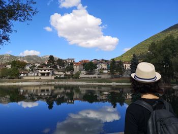 Rear view of man looking at view of buildings against sky