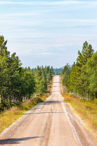 Road amidst trees against sky