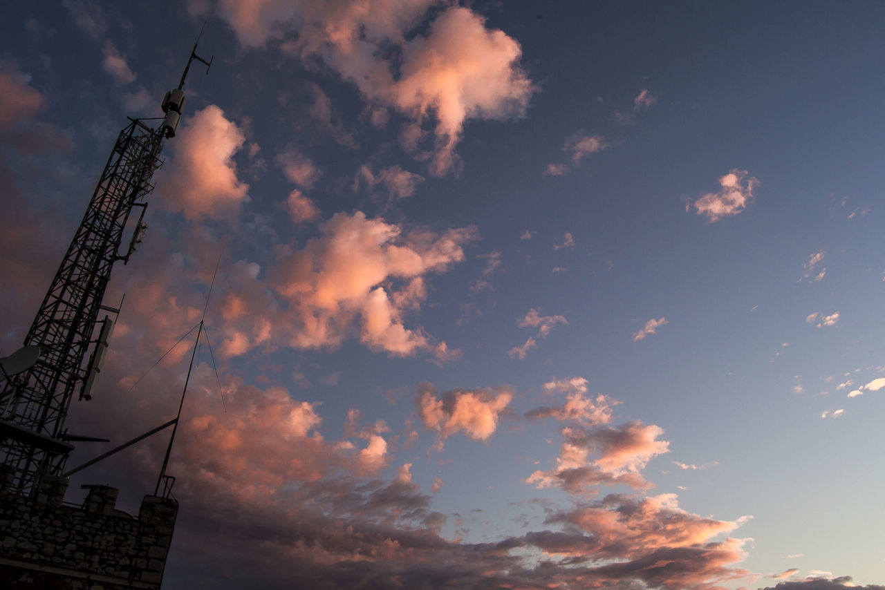 LOW ANGLE VIEW OF COMMUNICATIONS TOWER AGAINST SKY DURING SUNSET