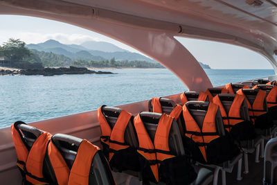 Chairs by sea against sky