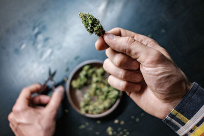 Cropped hands of man holding marijuana joint