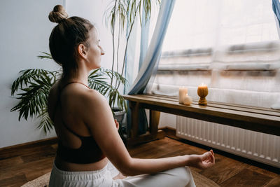 Girl looking away while sitting on floor at home