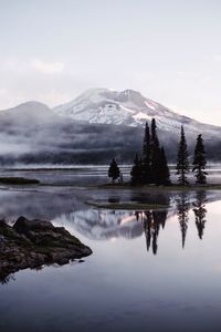Scenic view of lake and snowcapped mountains against sky