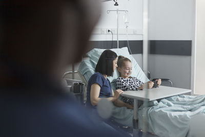 Nurse sitting with patient in hospital
