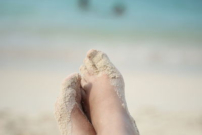 Low section of person on wet sand at beach