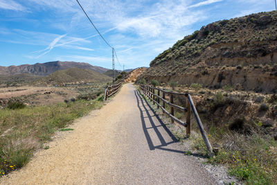 Road leading towards mountain against sky