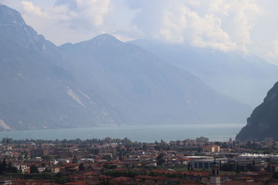 Aerial view of townscape and mountains against sky