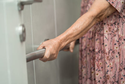 Cropped hand of man working on railing