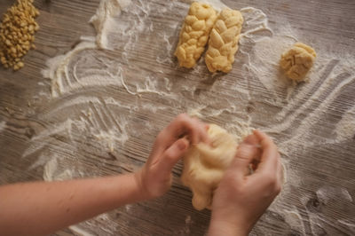 Cropped image of hand kneading dough on table