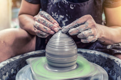 High angle view of woman working on pottery wheel