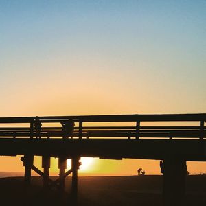 Bridge over river at sunset