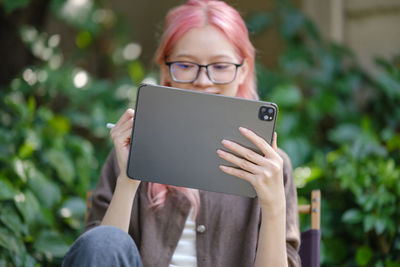 Midsection of woman using digital tablet