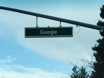 Low angle view of road sign against blue sky