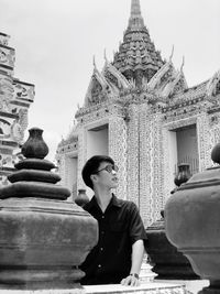 People at temple outside building against sky