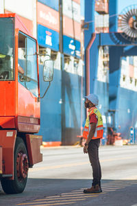 Side view of construction worker chatting to truck driver at the port