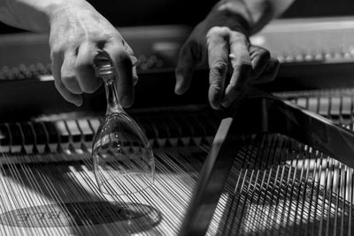 Pianist playing grand piano with a wineglass