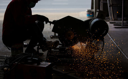 Welder used grinding stone on steel in factory with sparks, welding process at the industrial work