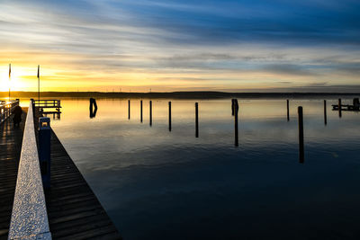 Pier on sea against sky during sunset