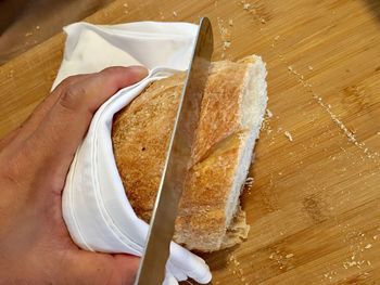 High angle view of person holding bread on table