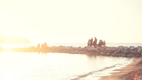 People on beach against clear sky