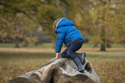 Full length of child on rock at park during autumn