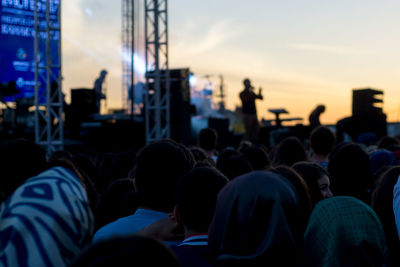 Crowd at music concert against sky