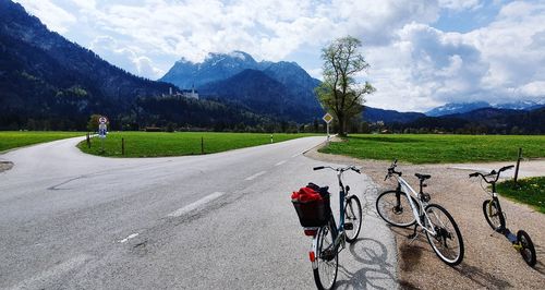 Bicycle on road by mountains against sky