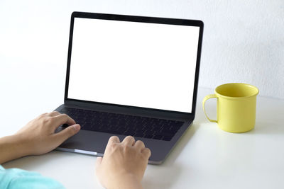 Midsection of man using mobile phone on table