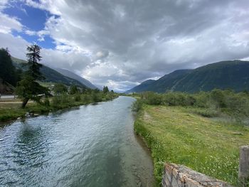 Scenic view of river amidst mountains against sky