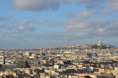 Cityscape against cloudy sky