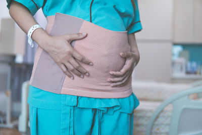 Midsection of woman standing against wall