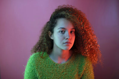 Portrait of young woman against gray background