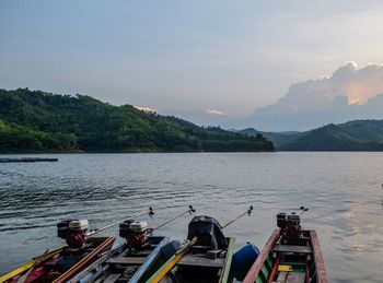 Scenic view of river by mountains against sky