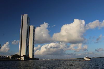 Scenic view of sea by buildings against sky