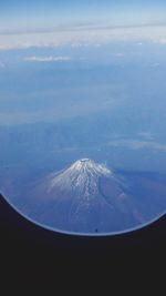 Aerial view of snowcapped mountains against sky