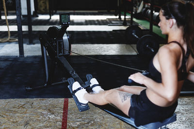 Side view of young woman exercising in gym